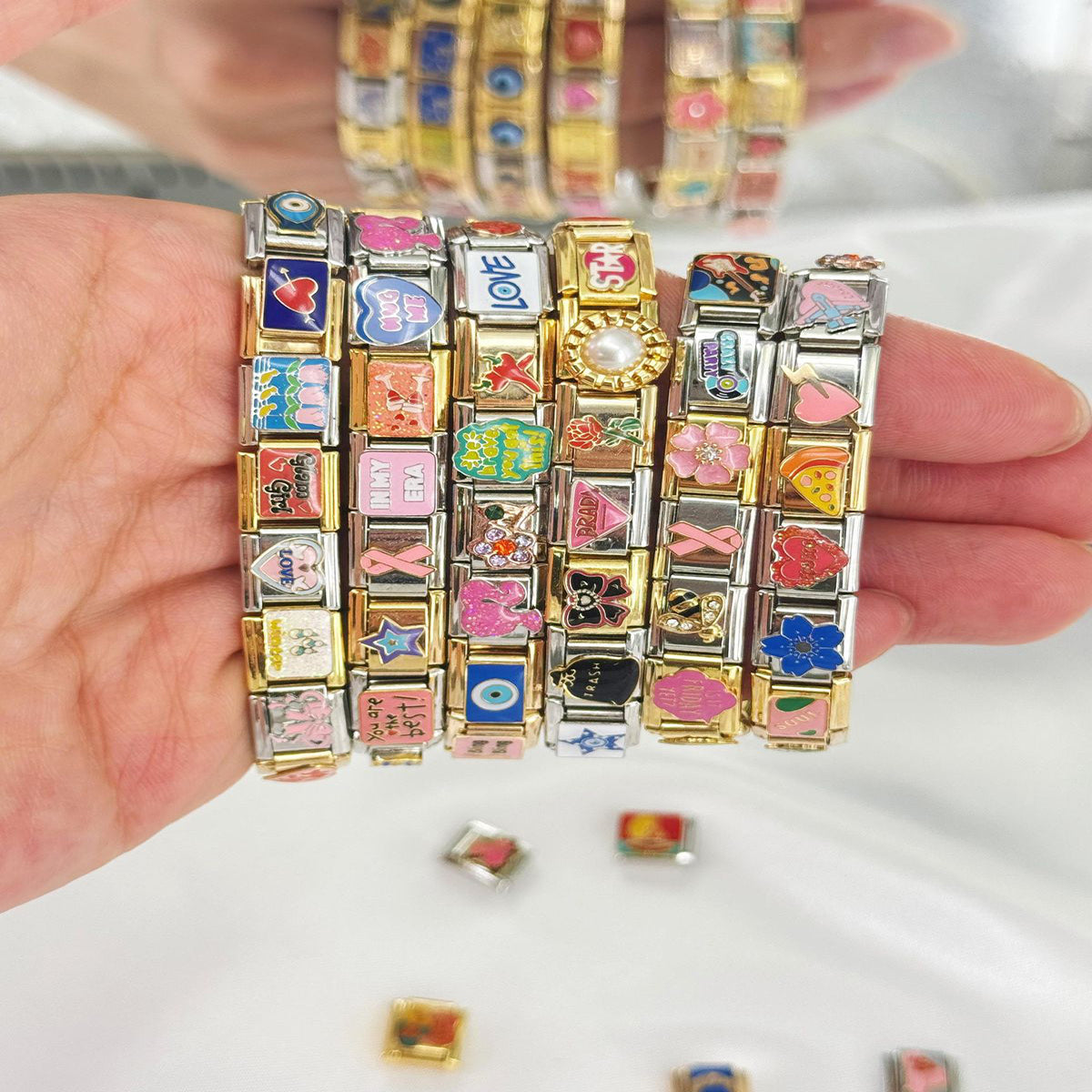 Woman wearing personalized Italian charm bracelets stacked with silver and gold charms