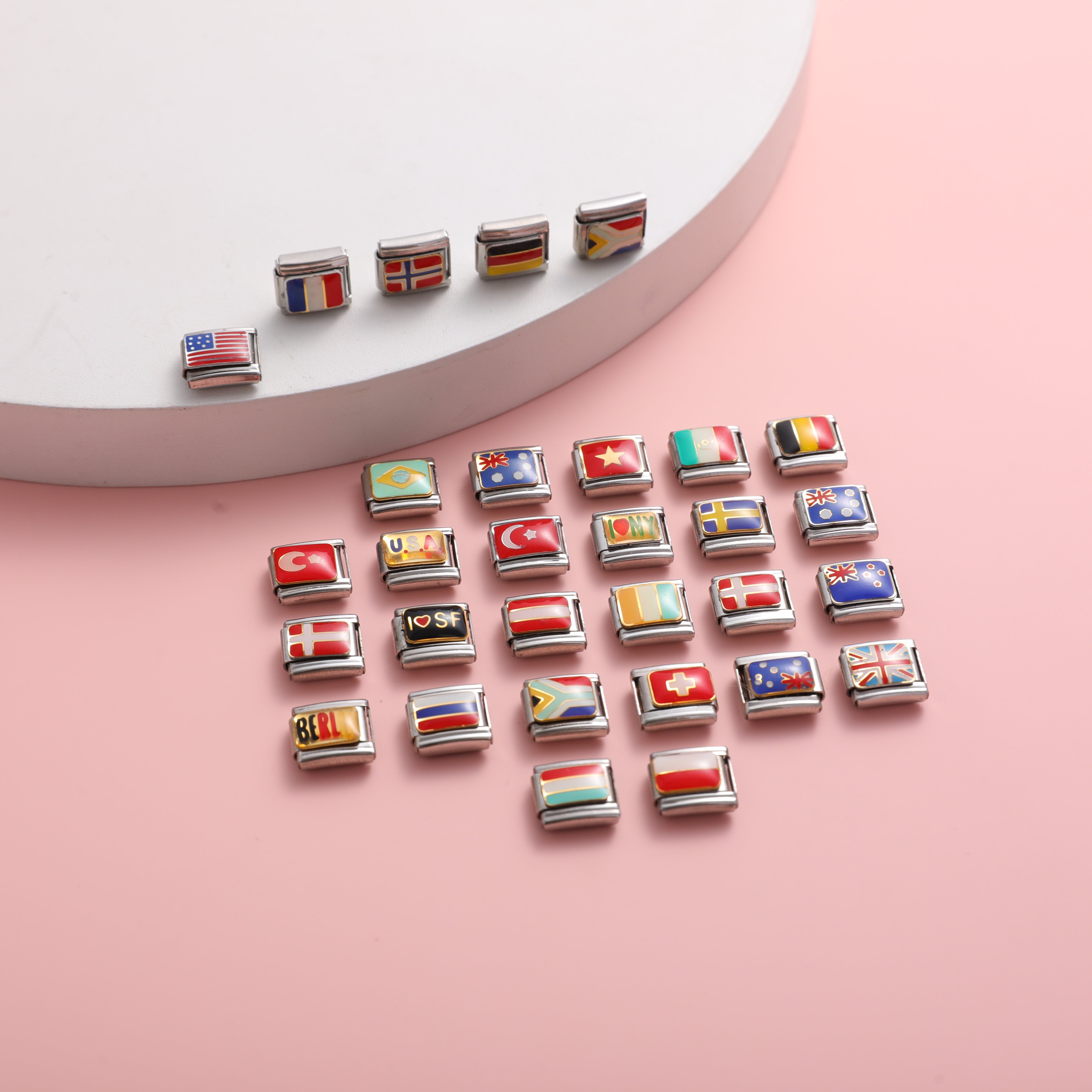Italian charm bracelet flag charms collection with USA, France, Germany, UK and more country flag links on pink background