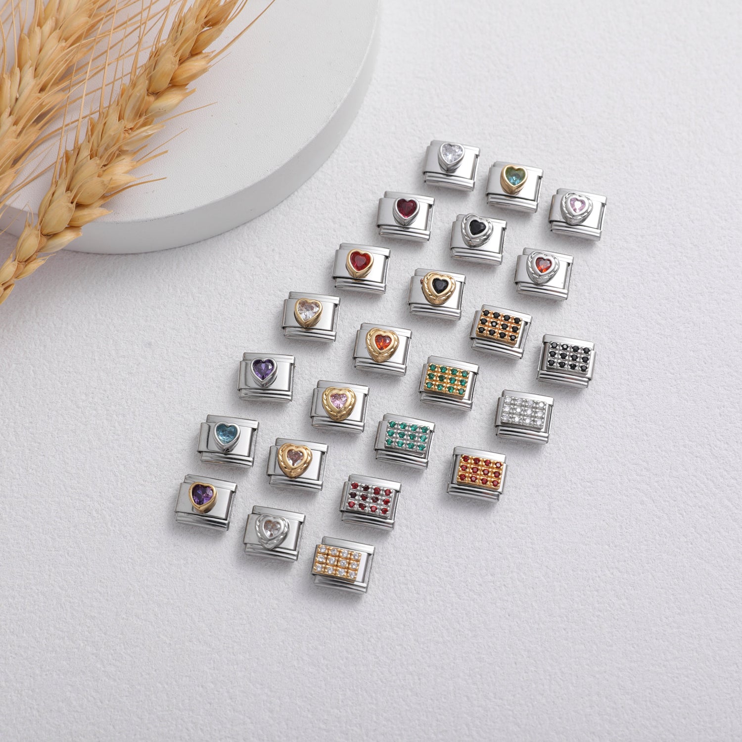 Heart shaped Italian charm bracelet links with colorful gemstones arranged on white background