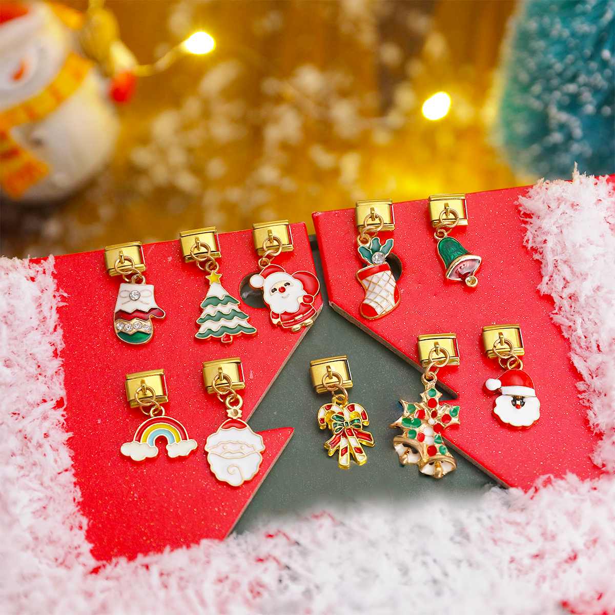 Gold Italian charm bracelet Christmas charms on red festive background, including Santa, stocking, Christmas tree rainbow and holly leaf enamel designs