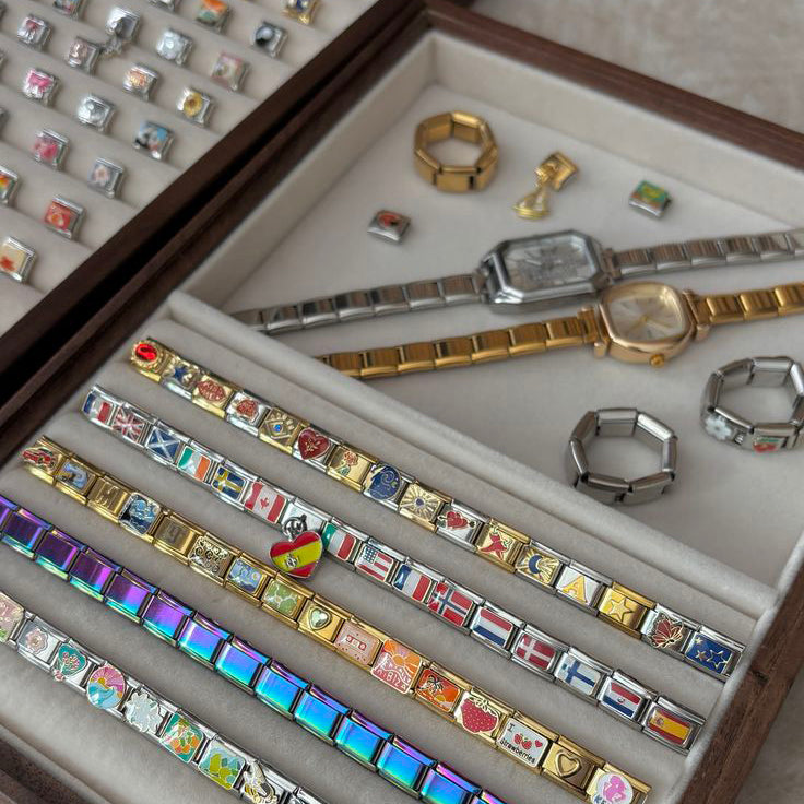 Elegant Italian charm bracelet displayed on elegant box, featuring silver and gold modular links with soft light reflections.