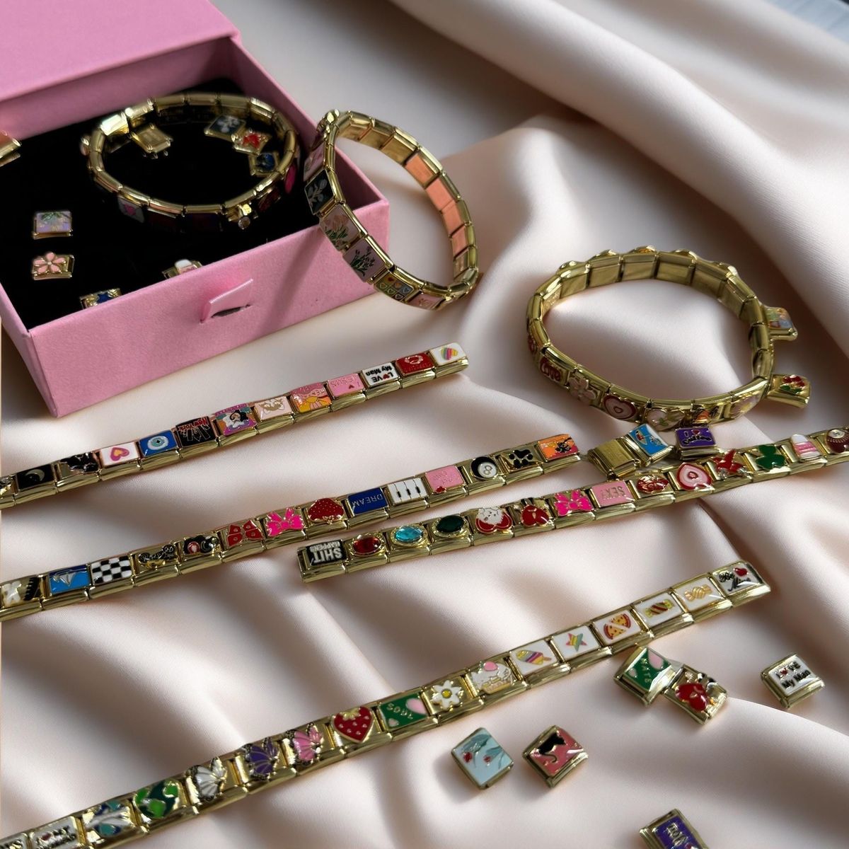 Elegant Italian charm bracelet displayed on beige fabric background showing quiet luxury minimalist jewelry aesthetic