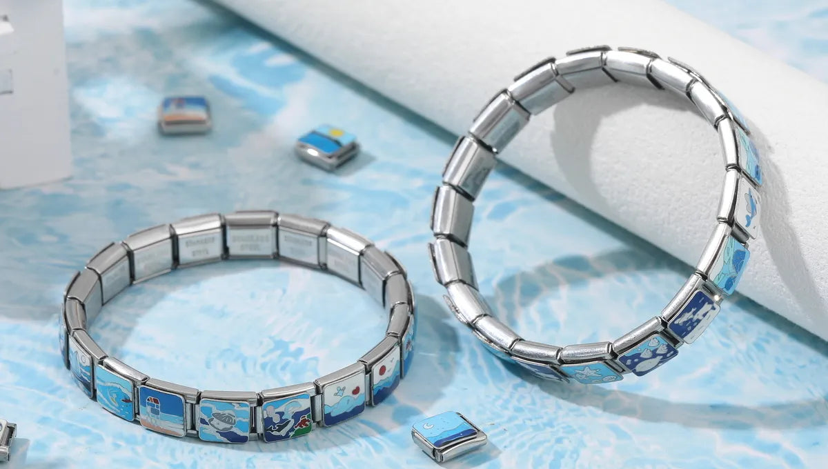 Two custom Italian charm bracelets placed on a styled scene with scattered modular charms around them, showcasing personalized jewelry options – CHARMSDIY