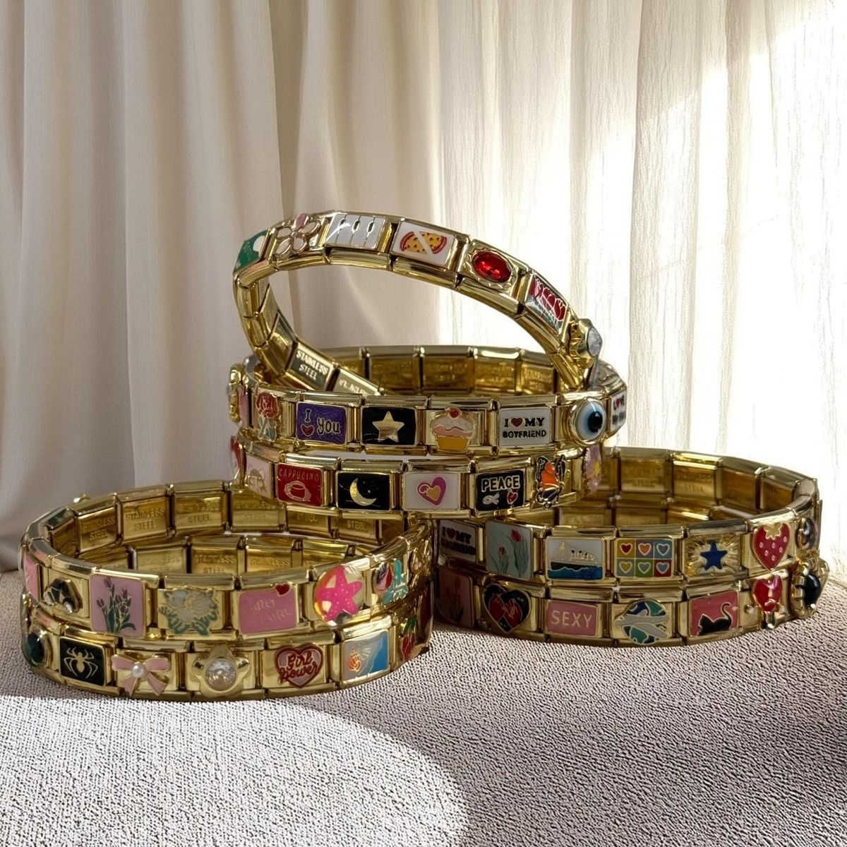 Multiple Italian charm bracelets arranged together showing modular links and different themes