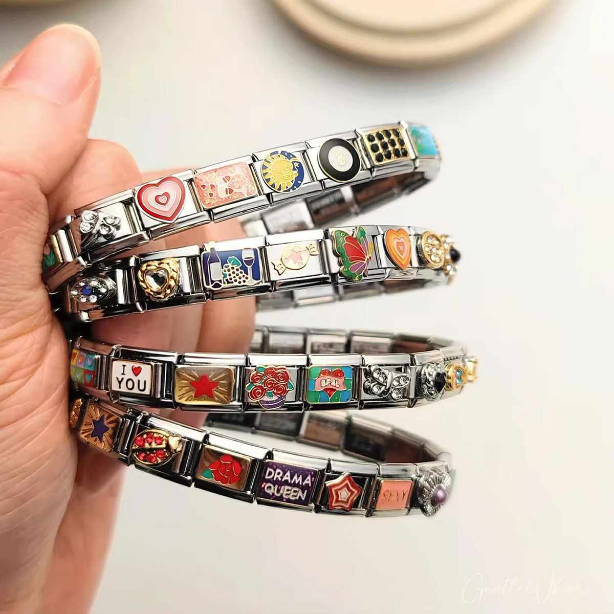 Close-up of a silver travel charm bracelet showing various travel charms