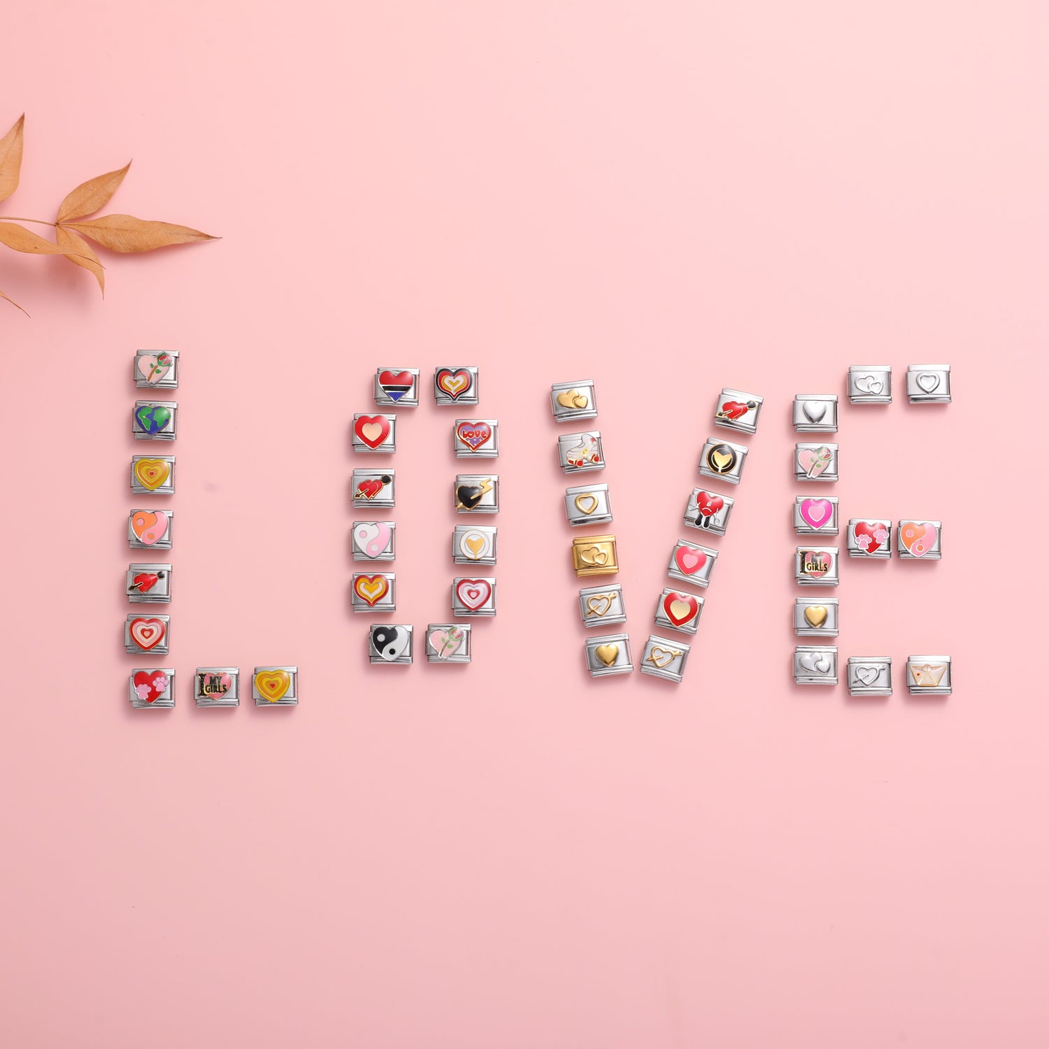 LOVE spelled with Italian charm bracelet links on a pink background featuring heart charms and romantic customizable bracelet ideas