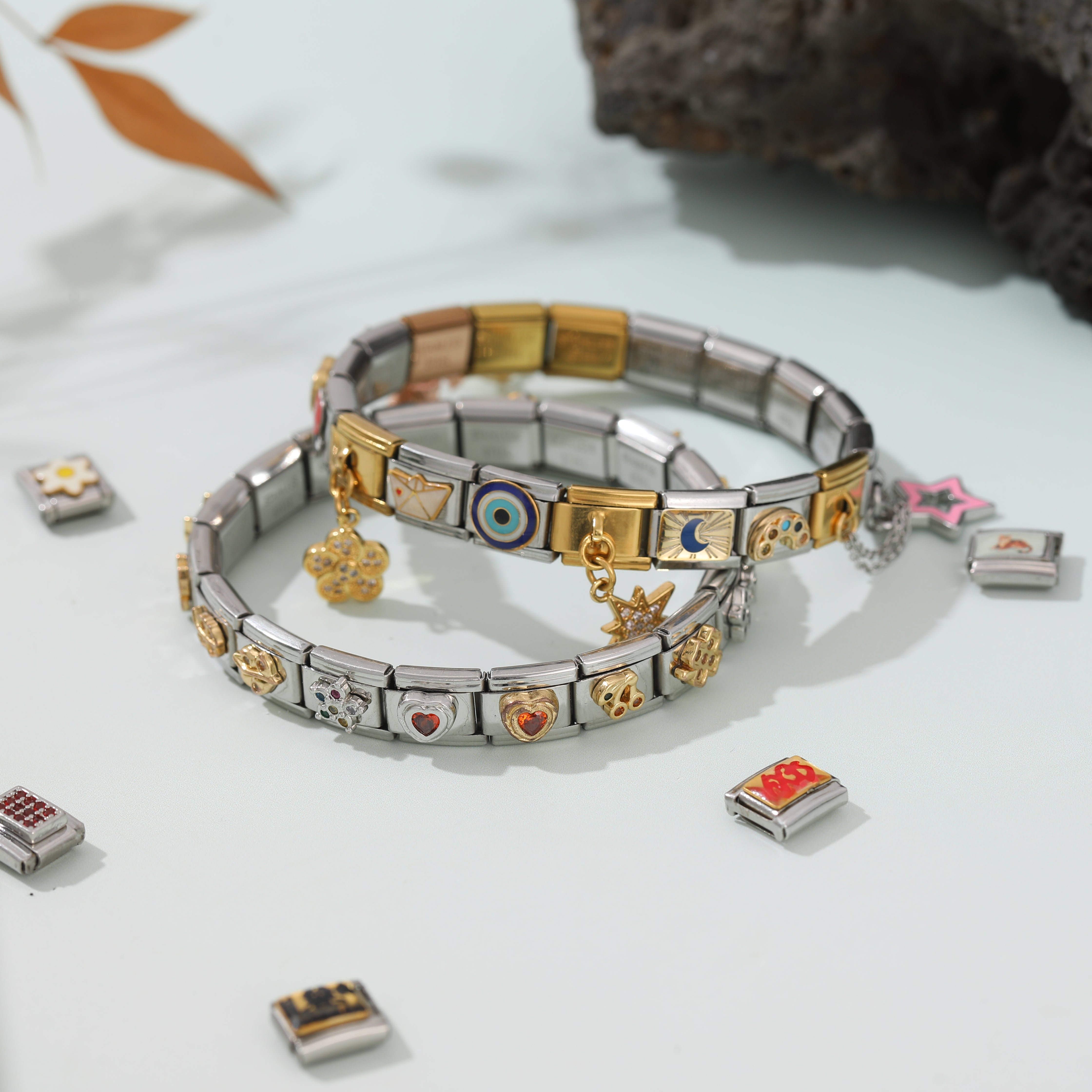 Two Italian charm bracelets styled with heart and symbol charms on a soft lifestyle background