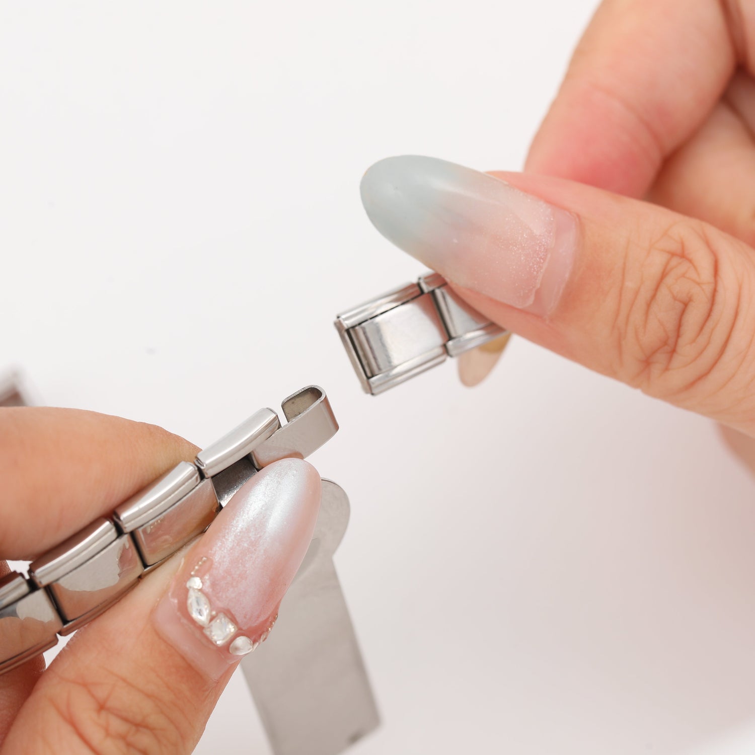 Italian charm bracelet with gold and silver modular links and dangling charms, showcasing a customizable Italian modular bracelet design